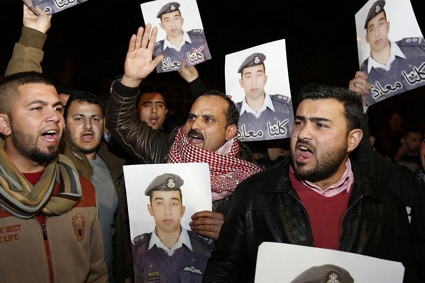 Relatives of captured pilot Muath al-Kasaesbeh holding up his pictures in front of the Jordanian prime minister's building in Amman on Jan 27 as they called for the government to negotiate with ISIS for his release. The militant group later released 