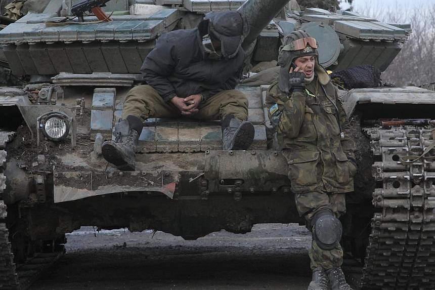 Ukrainian servicemen rest on a tank in Artyomovsk of Donetsk area, Ukraine on Sunday as world leaders met in Munich to try to broker a peace deal. -- PHOTO: EPA