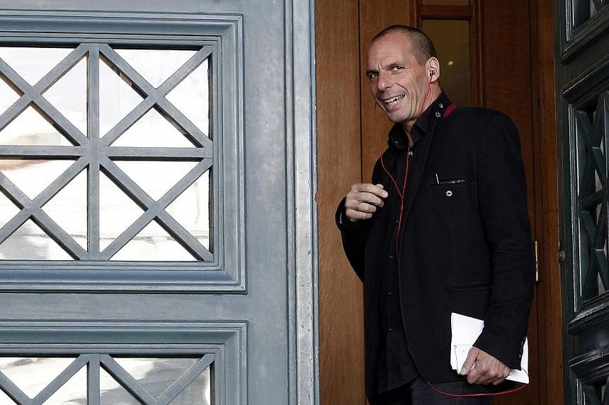 Greece's Finance Minister Yanis Varoufakis speaks on his phone upon arriving for a government meeting at the parliament building in Athens on Saturday. -- PHOTO: REUTERS