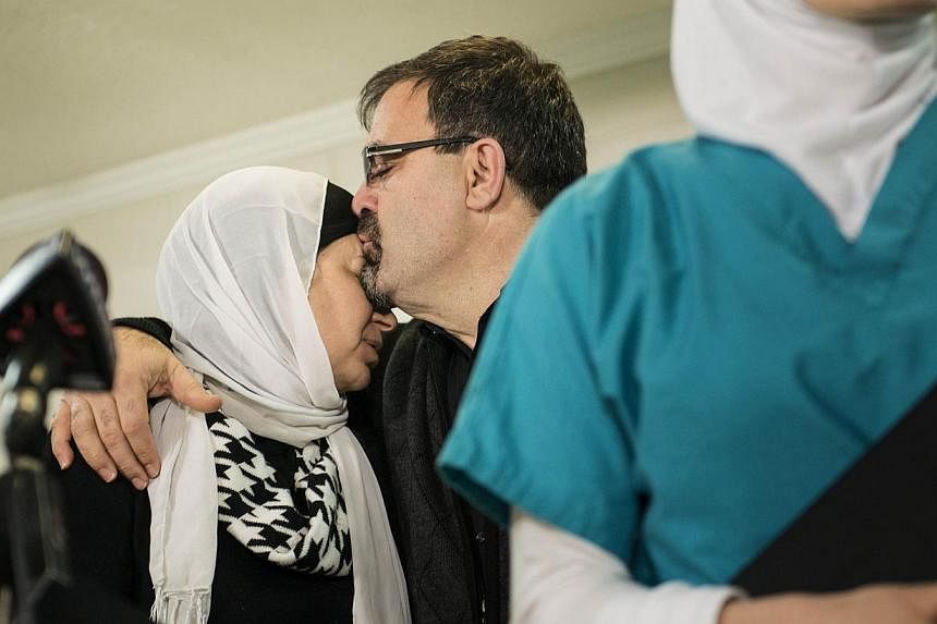 Mr Namee Barakat, father of Mr Deah Barakat, kisses his wife Leila Barakat after a press conference at Swift Creek Community Center in Chapel Hill, North Carolina on Feb 11, 2015. -- PHOTO: AFP
