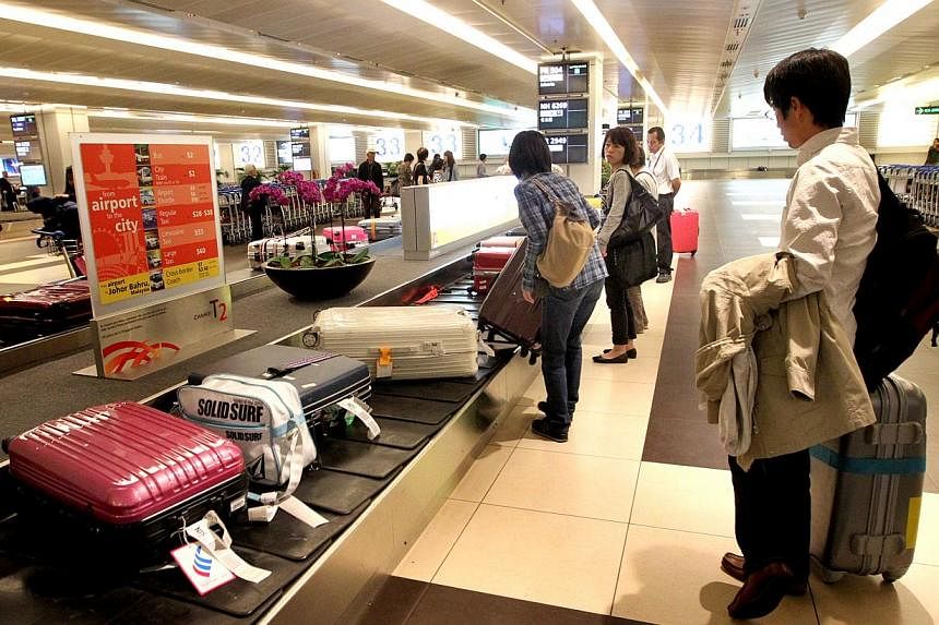 Changi Airport has set aside $17 million to find better methods of loading bags and cargo onto planes. -- PHOTO: ST FILE