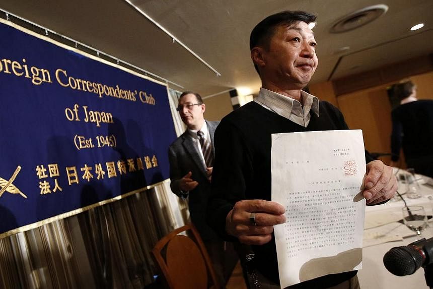 Japanese freelance photographer Yuichi Sugimoto (right) shows a mandate letter issued by Foreign Minister Fumio Kishida during a news conference at the Foreign Correspondents' Club of Japan in Tokyo Feb 12, 2015. Sugimoto&nbsp;accused the government 