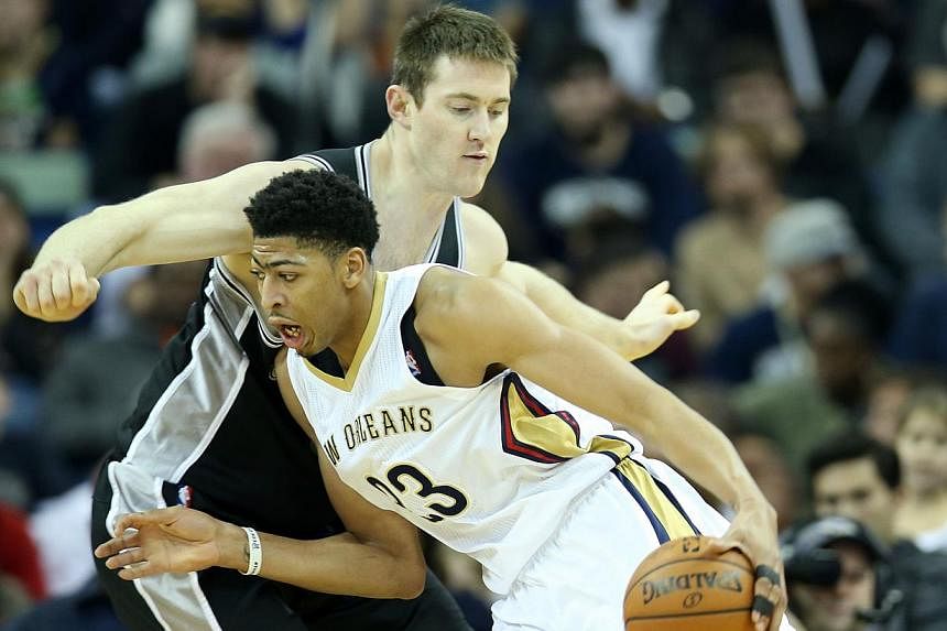 Anthony Davis #23 of the New Orleans Pelicans drives the ball around Tiago Splitter #22 of the San Antonio Spurs at Smoothie King Center on Dec 26, 2014, in New Orleans, Louisiana.&nbsp;Davis on Wednesday, Feb 12, 2015, became the latest player to pu
