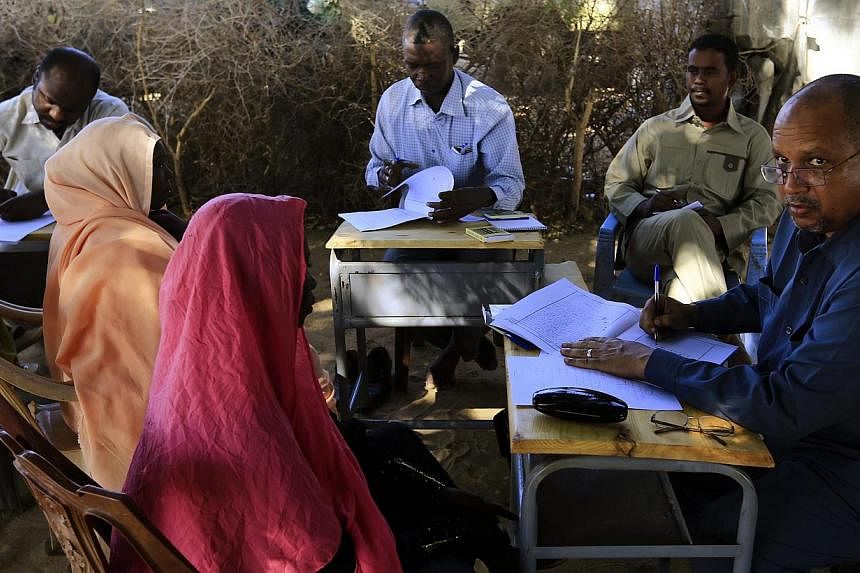 Special prosecutor for crimes in Darfur Yasir Ahmed Mohamed (right) and his team talk to women during an investigation into allegations of mass rape in the village of Tabit, in North Darfur, Nov 20, 2014. -- PHOTO: REUTERS