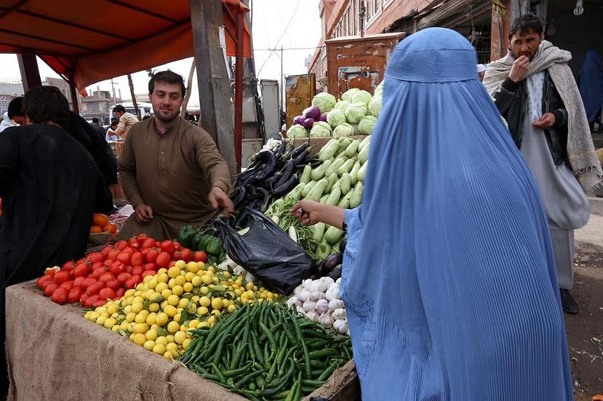 An Afghan man sells vegetables by the roadside in Herat, Afghanistan, Feb 10 2015.&nbsp;Afghanistan is to issue visas on arrival as it seeks to cut red tape to boost business in the impoverished country, the foreign ministry said Wednesday. -- PHOTO: