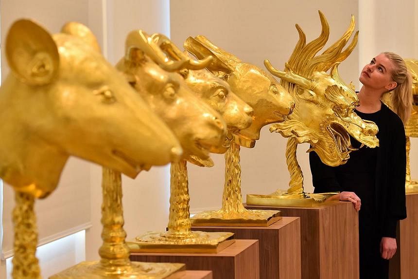 A set of 12 gold-plated animal head sculptures by China's Ai Weiwei sold for £2.8 million (S$5.8 million) at auction on Feb 12, 2015, setting a new record for the dissident artist's work. -- PHOTO: AFP
