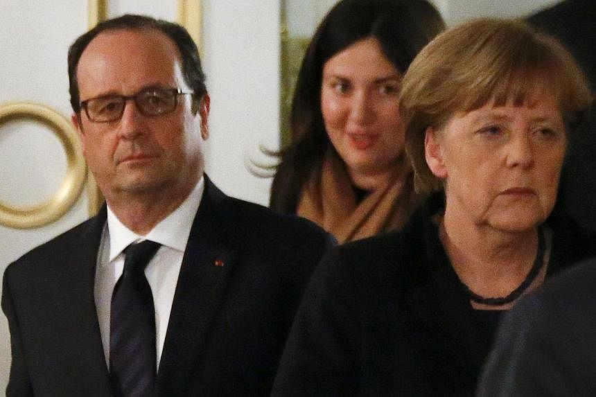 Germany's Chancellor Angela Merkel (right) and France's President Francois Hollande (left) walk as they attend a peace summit to resolve the Ukrainian crisis in Minsk on Feb 12, 2015. -- PHOTO: REUTERS