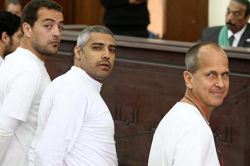 A March 31, 2014 photo shows Australian journalist Peter Greste (right), Canadian-Egyptian journalist Mohammed Fahmy (centre) and journalist Baher Mahmoud (left) on trial in Cairo, Egypt. -- PHOTO: EPA