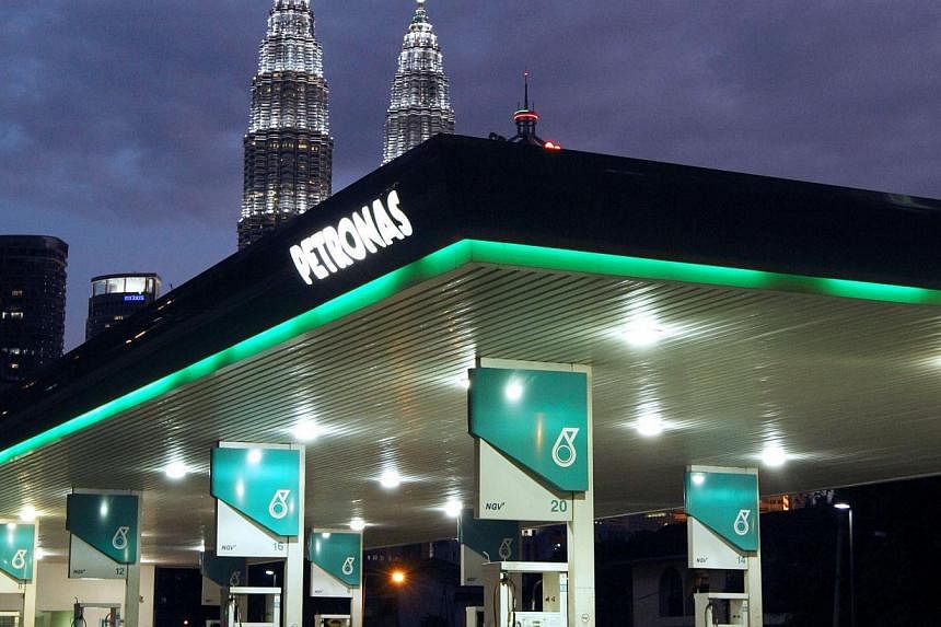 A Petronas petrol station is pictured in front of the Petronas Twin Towers in Kuala Lumpur. Malaysia's national oil company is paying for troubles at state investment fund 1MDB. -- PHOTO: BLOOMBERG
