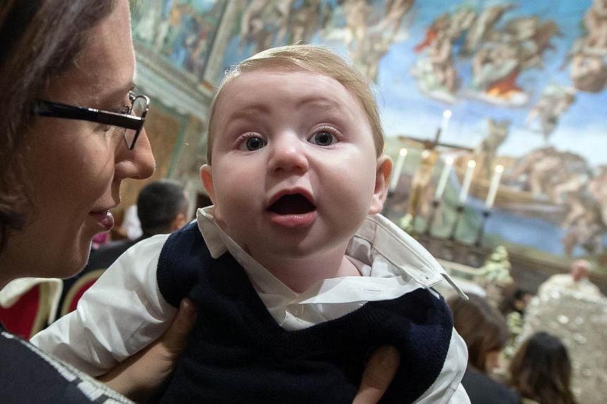 A woman holding a baby at the Vatican on&nbsp;Jan 11, 2015, as Pope Francis delivers a speech.&nbsp;Fewer babies were born in Italy in 2014 than in any other year since the modern Italian state was formed in 1861, new data shows, highlighting the dem