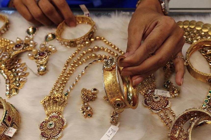 A woman looks at a gold bangle inside a jewellery showroom at a market in Mumbai Jan 15, 2015.&nbsp;China lost its place to India as the world's biggest gold consumer in 2014, sector data showed Thursday, hit by collapsing jewellery demand after one 