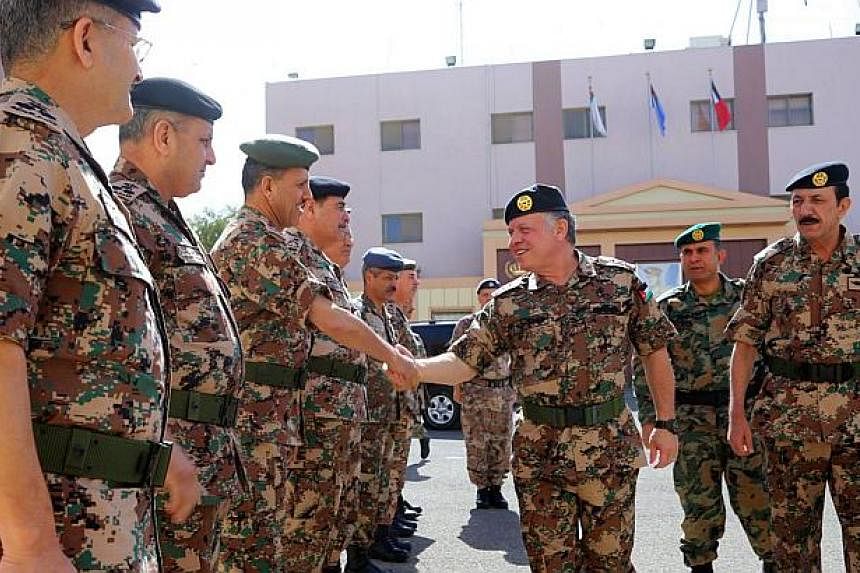 A handout picture released by the Jordanian Royal Palace shows Jordan's King Abdullah II greeting members of the Jordanian Armed Forces in Amman on Feb 12, 2015. -- PHOTO: AFP