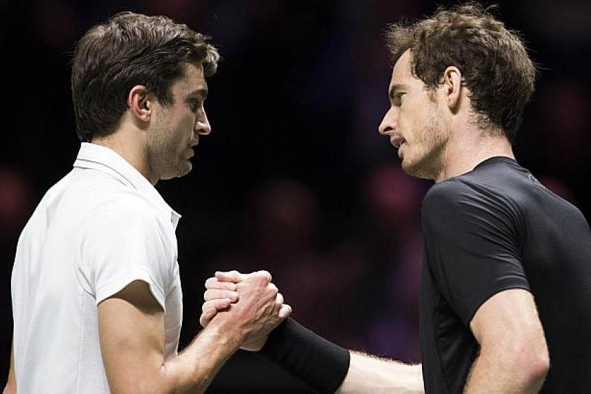 Gilles Simon (left) of France and Britain's Andy Murray shake hands at the end of their quarter-final match in Rotterdam on Feb 13, 2015. -- PHOTO: AFP