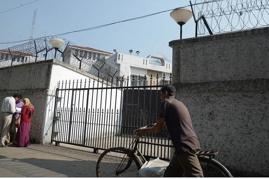 An Indian cyclist walks past the gates of The Consulate-General of Japan in Kolkata on Jan 5, 2015. An Indian tour guide accused of drugging and raping a Japanese woman this week in the northern city of Jaipur turned himself in to police on Friday, a