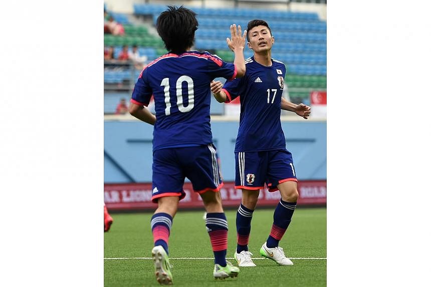 Japan's U-22 midfielders Nakajima Shoya (left) and Nozawa Hideyuki celebrating a goal against Singapore's U-23 team during their international friendly football match at Jalan Besar Stadium in Singapore on Feb 14, 2015.&nbsp;-- PHOTO: AFP