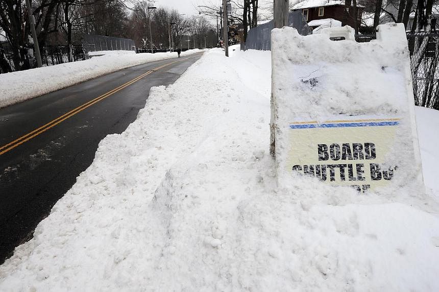A sign in a snow drift marks the shuttle bus service at the closed MBTA subway station in Boston, Massachusetts on&nbsp;Feb 10, 2015. -- PHOTO: REUTERS