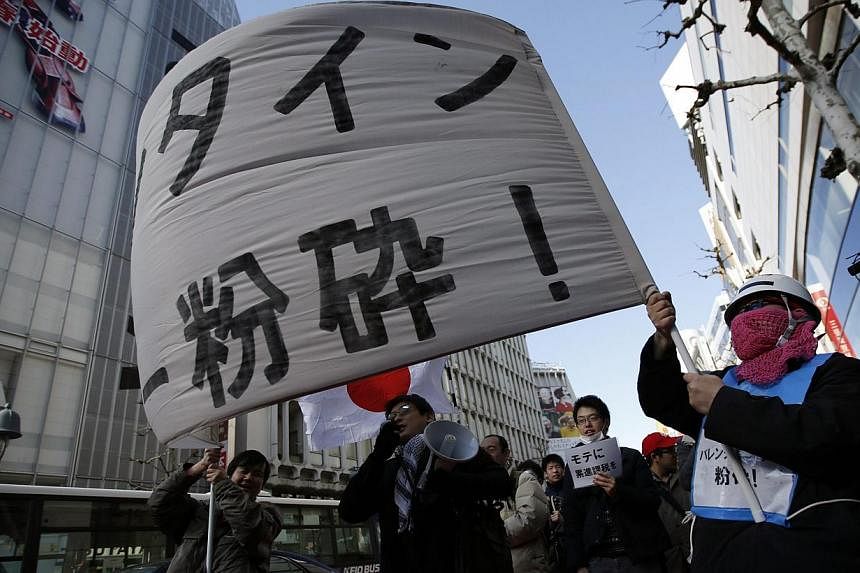 Protesters holding a&nbsp;banner reading "Smash Valentine's Day" as they shout slogans during a march at Tokyo's Shibuya shopping and amusement district on&nbsp;Feb 14, 2015. -- PHOTO: REUTERS