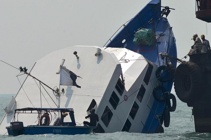 The bow of the Lamma IV boat is shown&nbsp;partially submerged during rescue operations the morning after it collided with a Hong Kong ferry on Oct 2, 2012. -- PHOTO: AFP