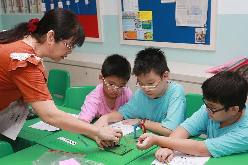A volunteer helping pupils at a Chinese Development Assistance Council (CDAC) tuition centre in Sengkang. Around 17,600 households benefited from schemes under CDAC last year. -- PHOTO: LIANHE ZAOBAO