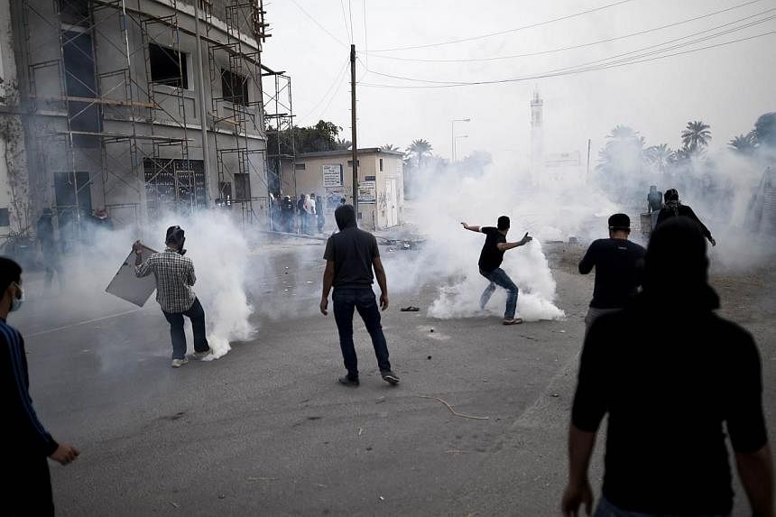 A Bahraini protester throwing back a tear gas canister during clashes with police following a demonstration on Feb 13, 2015, marking the fourth anniversary of the Arab Spring-inspired uprising and against the recent arrest of Sheikh Ali Salman, head 
