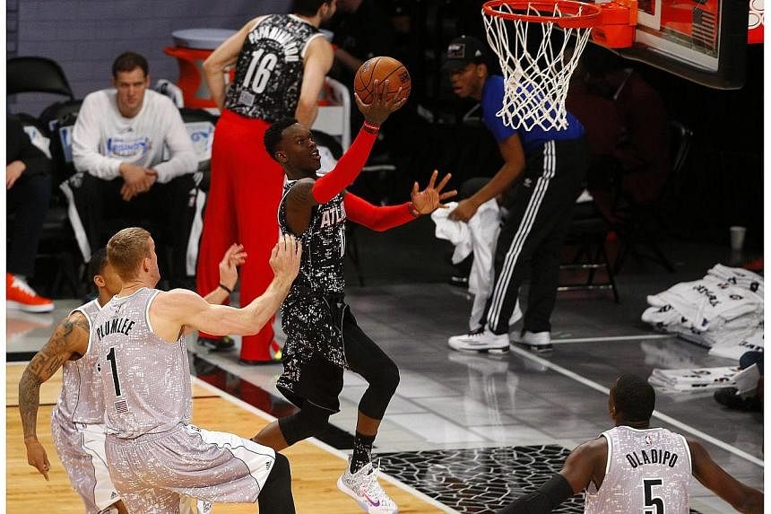 Dennis Schroeder of the Atlanta Hawks (centre) goes to the basket in the BBVA Compass Risings Stars Challenge at the Barclays Center in Brooklyn, New York, US, on Feb 13, 2015. -- PHOTO: EPA