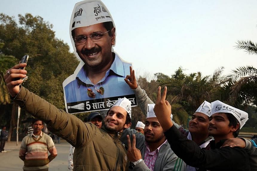 Young Aam Aadmi Party (AAP) supporters taking a selfie with AAP convener Arvind Kejriwal's cutout picture as they celebrate a landslide win in the Delhi Legislative Assembly elections, in Amritsar, India, on Feb 10, 2015. -- PHOTO: EPA