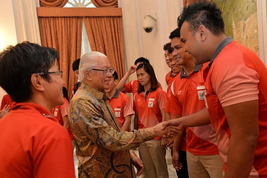 President Tony Tan Keng Yam meeting sepak takraw team members Muhammad Danial Feriza Padzil (right) and team captain Mohamad Farhan Amran (second from right), at Istana reception in honour of Team Singapore athletes and their feats at the various maj