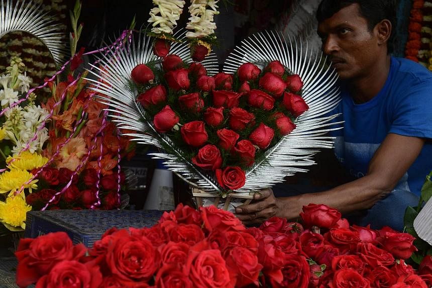 An Indian flower seller arranges varieties of roses at a roadside stall ahead of Valentine's Day in Siliguri on Feb 13, 2015.&nbsp;Right-wing Hindus in India are offering white roses, free counselling and a chance to get married for couples caught ki