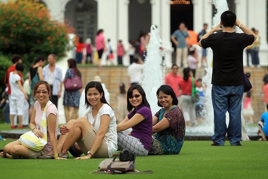 A group of friends on the lawn in front of the Istana building during the open house on Feb 11, 2013. -- ST PHOTO:&nbsp;NEO XIAOBIN