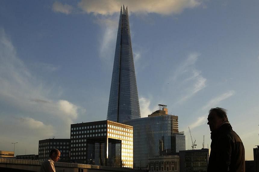 Workers pass the Shard on the opposite bank of the River Thames in the City of London on Jan 16, 2015.&nbsp;Popular destinations in the UK are being renamed to attract more Chinese tourists - the&nbsp;Shard, for instance, will be named Zhaixing Ta, w