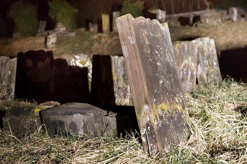 Overturned grave stones in the Jewish cemetery in Saare-Union, France on Feb 15, 2015.&nbsp;Five adolescents aged 15 to 17 have been taken into custody in eastern France for questioning over the vandalism. -- PHOTO: EPA