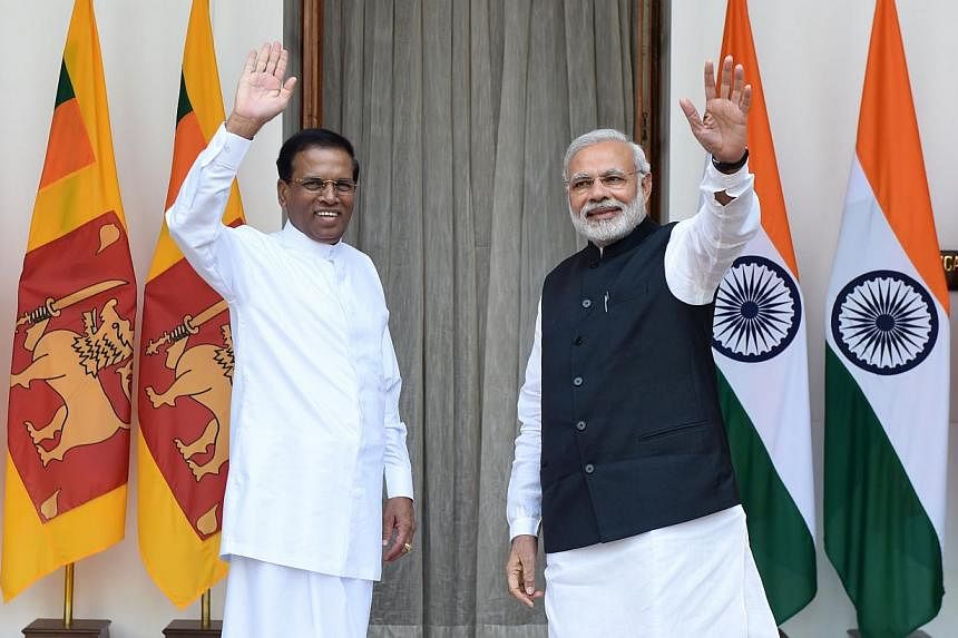 Indian Prime Minister Narendra Modi (right) and Sri Lankan President Maithripala Sirisena waving prior to a meeting and delegation-level talks in New Delhi on Feb 16, 2015.&nbsp;-- PHOTO: AFP