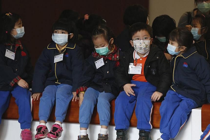 Children in masks visiting Hong Kong's Legislative Council last Friday. The flu death toll so far this year has hit 196, up from 133 early last year.