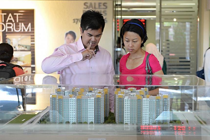 People looking at models of HDB flats. Analysts said a decreased BTO supply last year may have contributed to the dip in the number of applications. There were 22,455 BTO flats offered last year, down from 26,494 in 2013. -- PHOTO: ST FILE&nbsp;