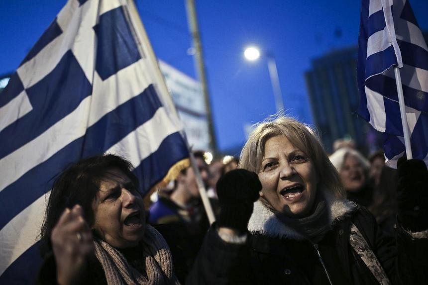 People shout slogans and wave Greek flags during an anti-austerity, pro-government rally in front of the Greek Parliament in Athens on February 15, 2015. -- PHOTO: AFP