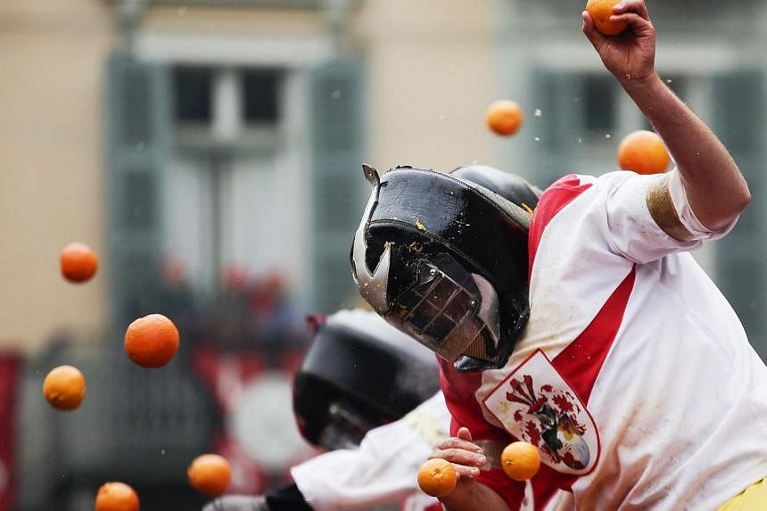 Members of rival teams fight with oranges during an annual carnival battle in the northern Italian town of Ivrea on Feb 15, 2015. -- PHOTO: REUTERS