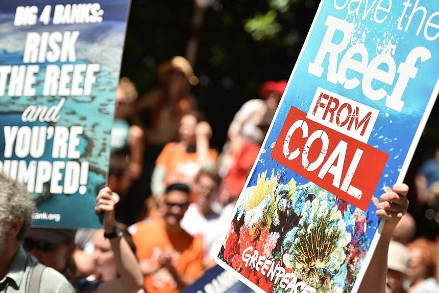 Protesters hold banners outside the headquarters of the Commonwealth Bank to say no to coal expansion on the Great Barrier Reef as part of "Global Divestment Day" in Sydney on Feb 13, 2015. -- PHOTO: AFP