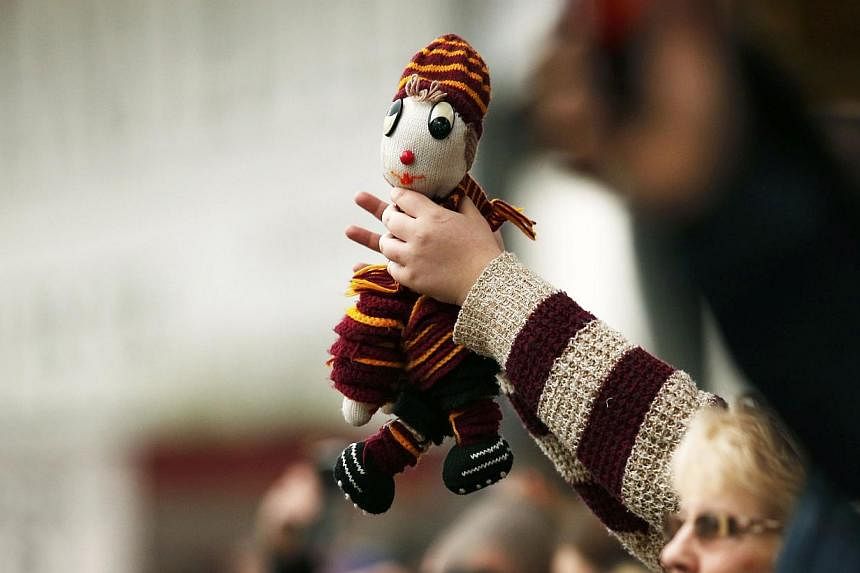 A Bradford City supporter holds a mascot during their FA Cup fifth round soccer match against Sunderland at Valley Parade in Bradford, northern England on Sunday. -- PHOTO: REUTERS