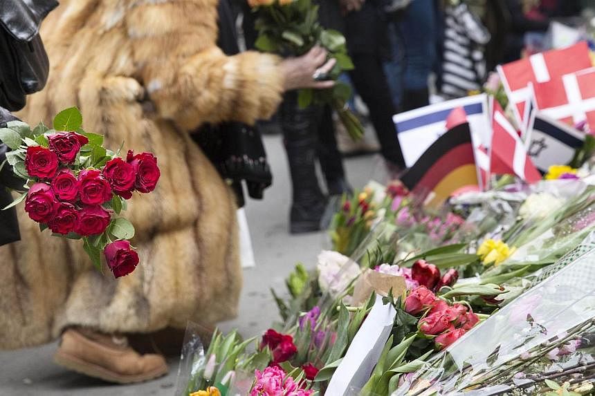 People put flowers to honour the shooting victims outside the main Synagogue of Copenhagen on Monday, after last week-end two fatal attacks.&nbsp;-- PHOTO: AFP