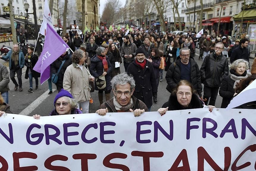 Protesters hold a banner reading "In Greece, in France, resistance" as they march during a demonstration in support of the Greek people on Sunday in Paris. -- PHOTO: AFP&nbsp;