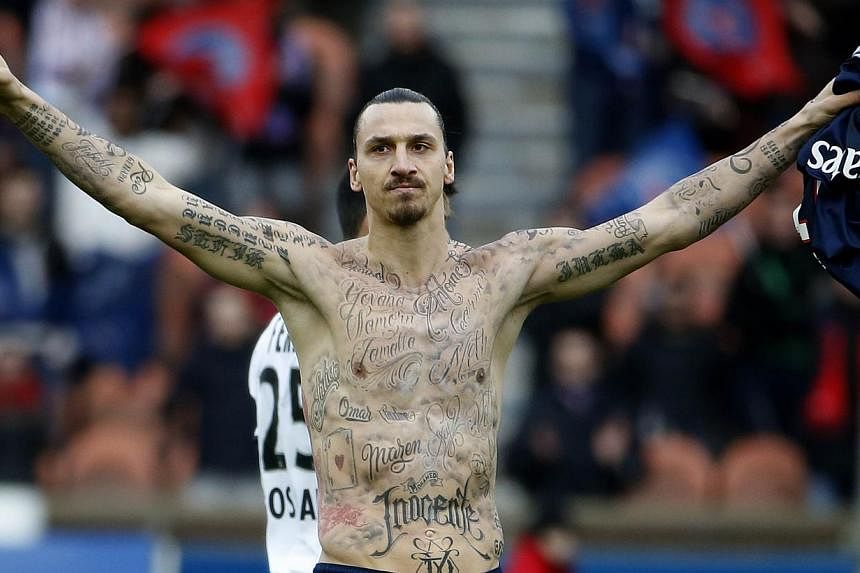 Paris Saint-Germain's Swedish forward Zlatan Ibrahimovic celebrates after scoring during the French L1 football match against Caen at the Parc des Princes stadium in Paris on Feb 14, 2015 by showing off tattoos of the&nbsp;names of people who do not 