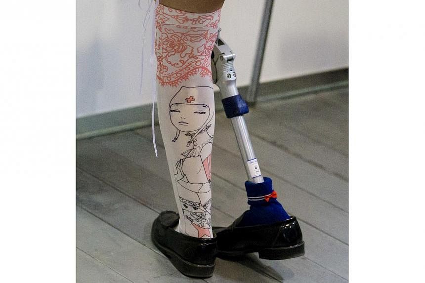 A woman wearing a prosthetic leg at the Hasselblad and Profoto booth, during the CP+ camera and imaging equipment trade fair in Yokohama on Feb 14, 2015. -- PHOTO: REUTERS