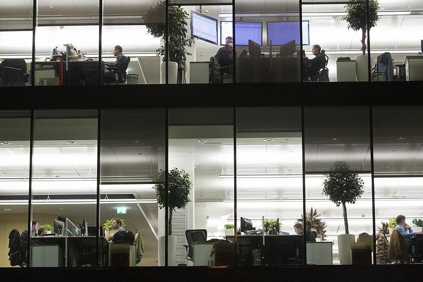 Employees work at their desks in offices inside the headquarters of Kaspersky Lab, a cyber-security firm, in Moscow, Russia, on Dec 9, 2014. -- PHOTO: BLOOMBERG&nbsp;