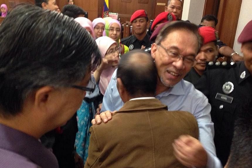 Malaysian opposition leader Anwar Ibrahim hugging his younger brother Rosli at court on Tuesday, Feb 17, 2015. Anwar is in court to give evidence in a defamation suit against Foreign Minister Anifah Aman. -- PHOTO: PARTI KEADILAN RAKYAT (PKR)