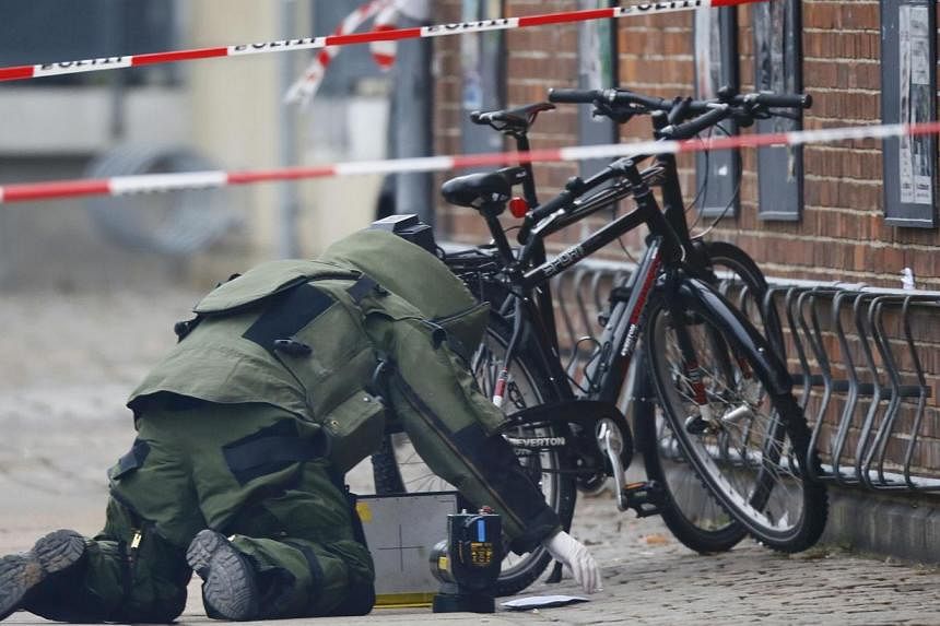 A bomb disposal expert investigates an unattended package in front of a cafe in Oesterbro, Copenhagen on Feb 17, 2015. No explosives were found in the package, Danish police said later on in a twitter message. -- PHOTO: REUTERS