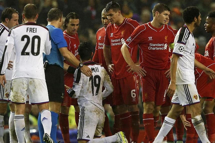 Liverpool's Lazar Markovic (fourth left) looks at FC Basel's Behrang Safari (fifth left) after being sent off during their Champions League Group B soccer match at Anfield in Liverpool, northern England, Dec 9, 2014. -- PHOTO: REUTERS