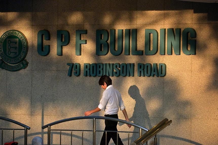 People walking past the CPF Building logo at the foot of the building along Robinson Road. -- PHOTO: ST FILE