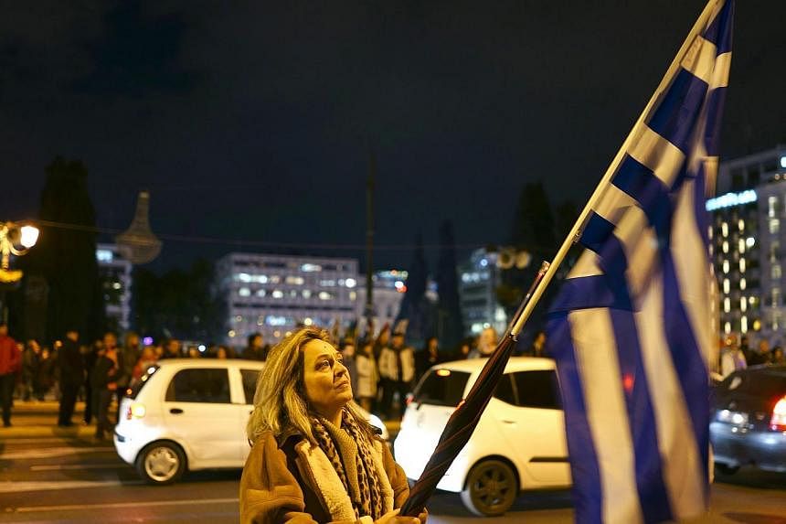 A protester holding a Greek flag as she takes part in an anti-austerity, pro-government demonstration in Athens on Monday. -- PHOTO: REUTERS
