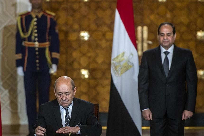 French Defence minister Jean-Yves Le Drian (left) signs military contracts with his Egyptian counterpart in the presence of Egyptian President Abdel Fattah al-Sisi (right) on Mondayat the presidential palace in the capital Cairo. Eric Trappier, chief