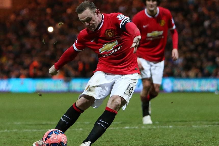 Manchester United's Wayne Rooney scores their third goal with a penalty. -- PHOTO: REUTERS